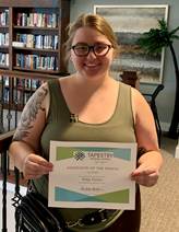 Riley Fisher holding her Associate of the Month certificate